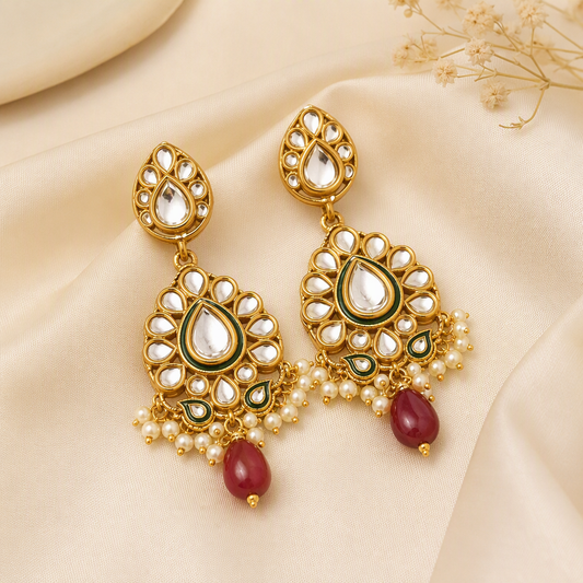 Pair of kundan style gold drop earrings on silk