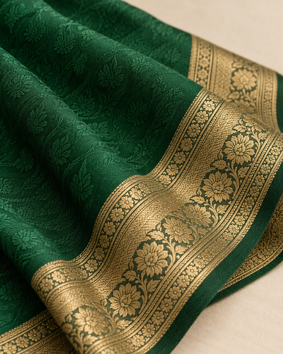 Close view of the emerald saree weave texture meeting the antique gold border
